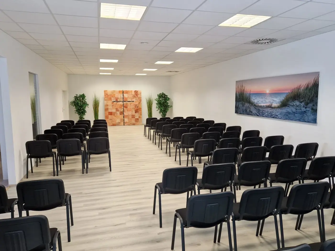 Trauerhalle des Bestattungshauses Wilke mit Stuhlreihen und Holzkreuz
